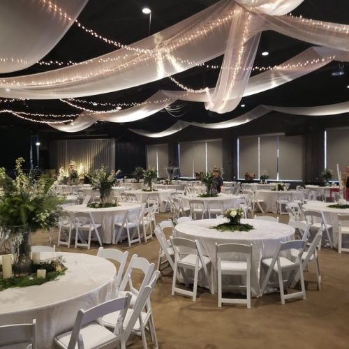 Outdoor corporate gala dinner setup with round tables and white linens